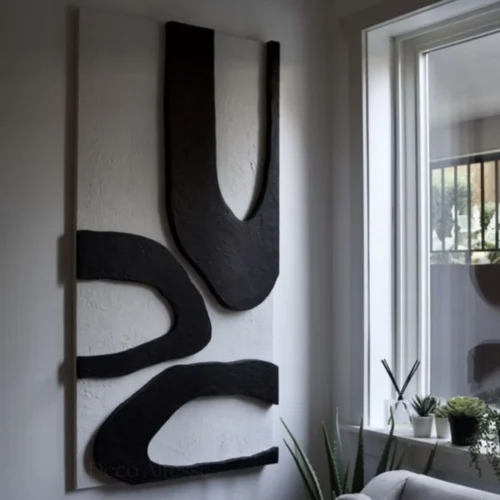 Tableau mural 3D sculpture noire et blanc à accroché dans un mur blanc