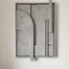 Tableau relief 3D modernre accroché sur un mur semi-blanc.