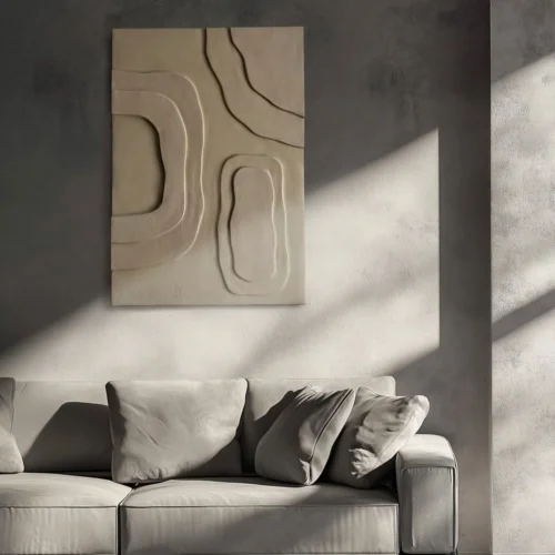 tableau 3D charme en relief beige accroché sur un mur de solon beige de gris bohème accroché sur un mur de solon beige-gris bohème et à coté en se trouve un canapé moderne également gris