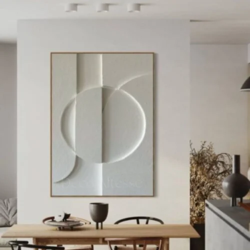 tableau 3D en relief encadré en bois de chêne accroché sur un mur blanc dans une salle à manger moderne.