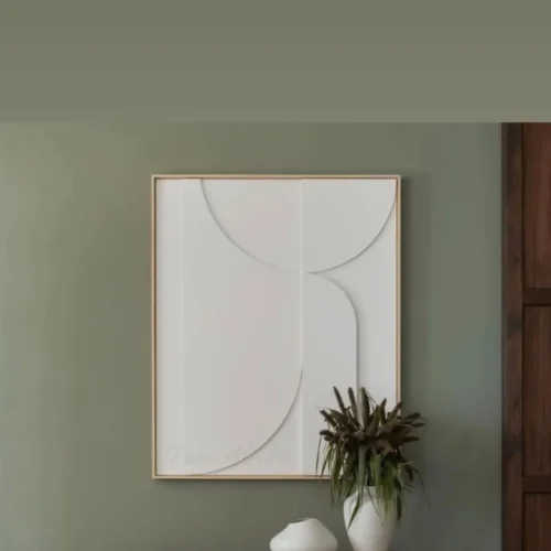 Tableau décoratif 3D relief blanc fait main contemporain, accroché sur un mur vert à l'entrée de la maison.